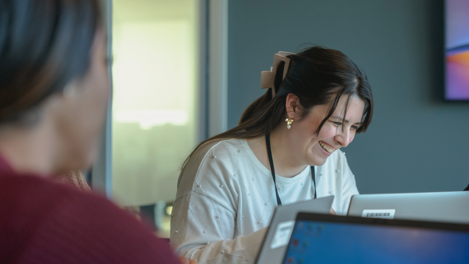 a person smiling at a laptop