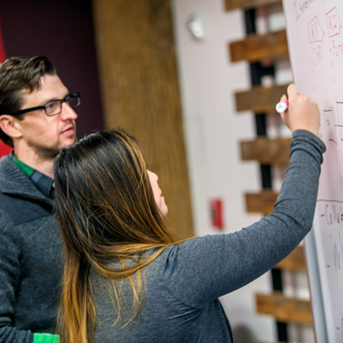 Cox employees writing on a white board