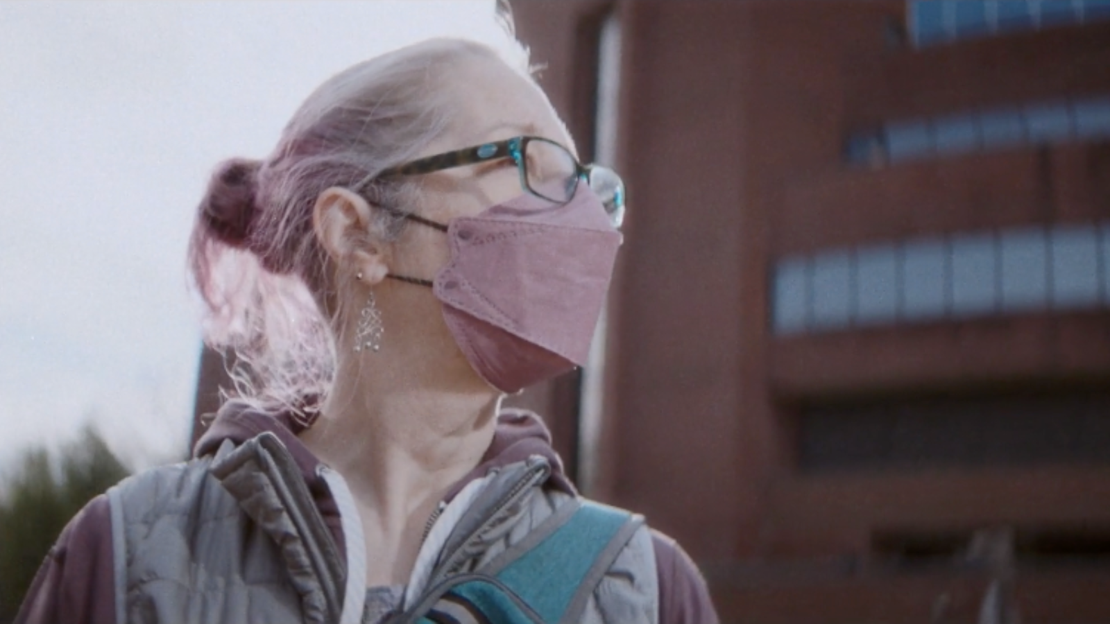 a person wearing a pink face mask