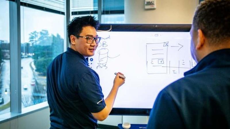 Cox Media employees collaborating on whiteboard