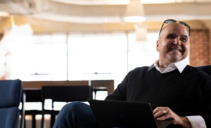 Cox employee smiling with his laptop