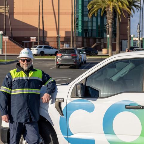 Cox automotive employee leaning on a car