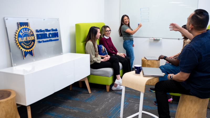 Kelly Blue Book Employees collaborating on whiteboard