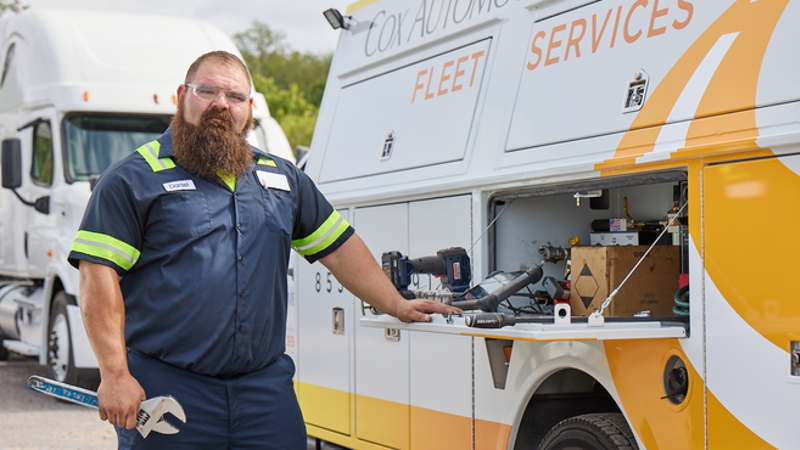 a Cox employee standing next to a van