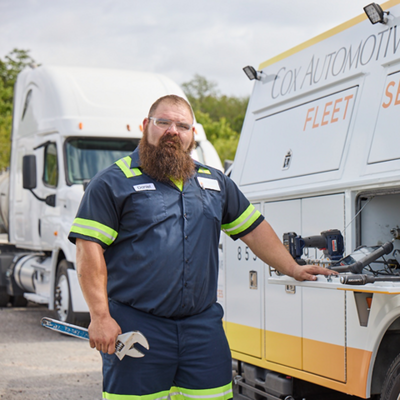 a Cox employee standing next to a van