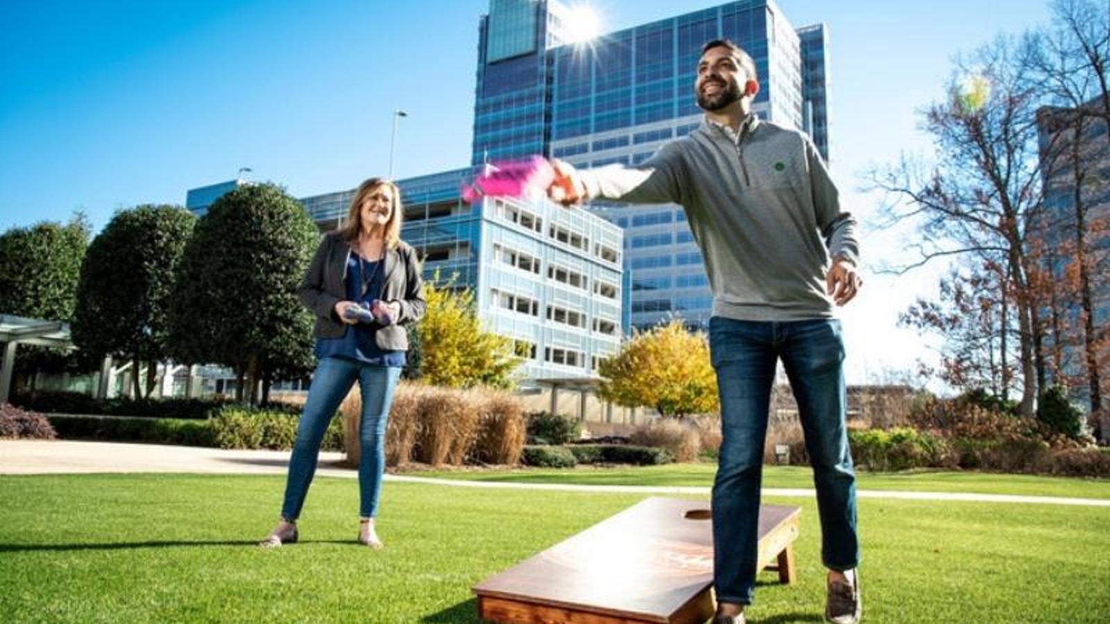 Cox employees Amit Vyas and Anne Gilk playing cornhole