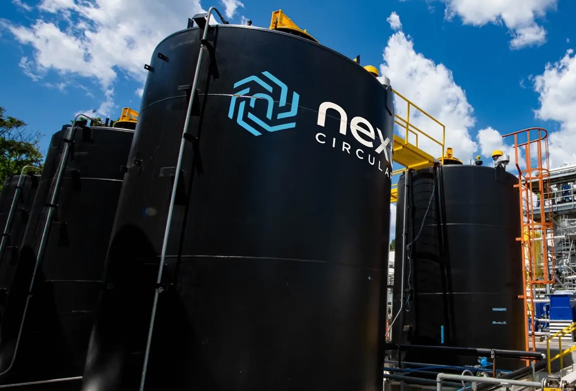 a group of black tanks with blue sky and clouds