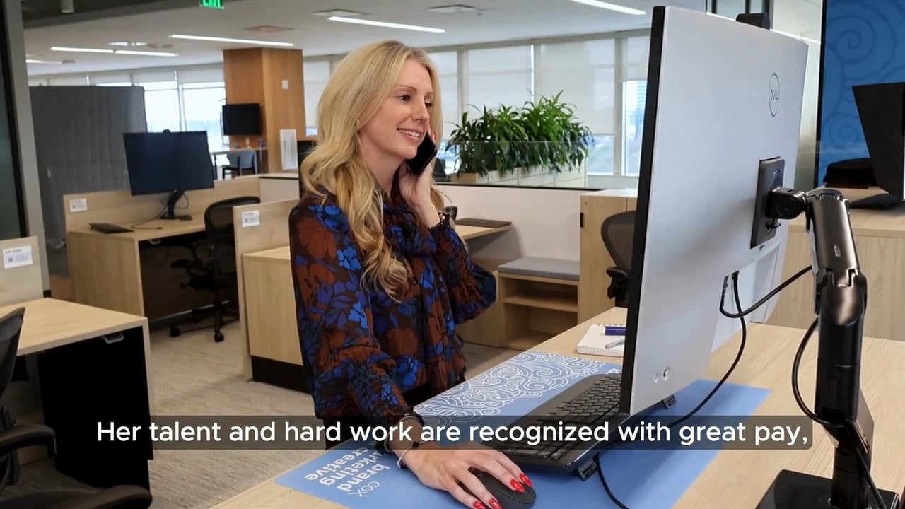cox employee sitting at a desk talking on the phone