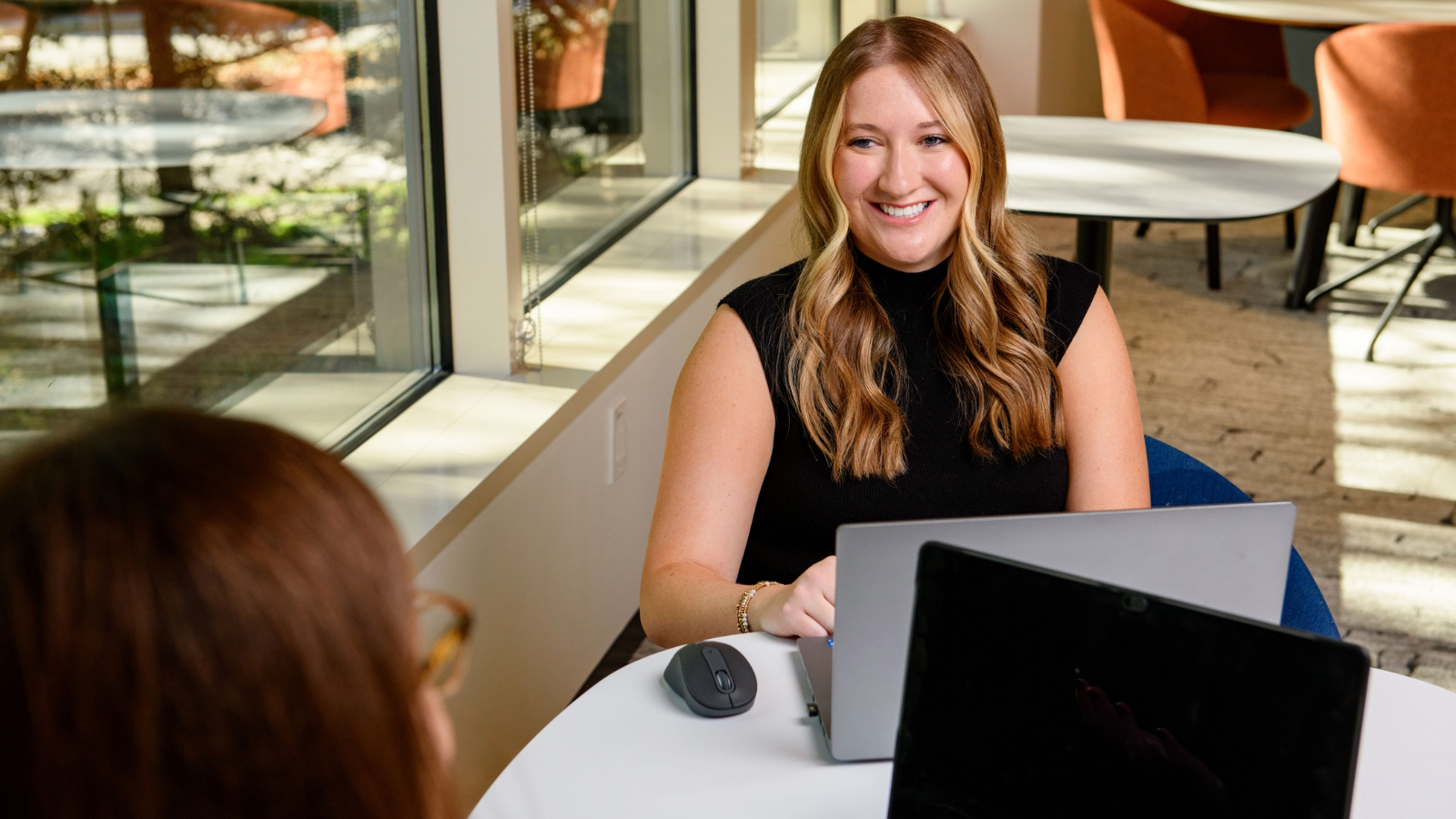 a person sitting at a table with a laptop