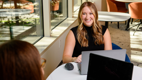 a person sitting at a table with a laptop