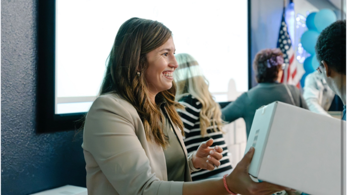 a Manheim general manager similar while handing out a box to someone off camera.