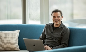a person sitting on a couch with a laptop