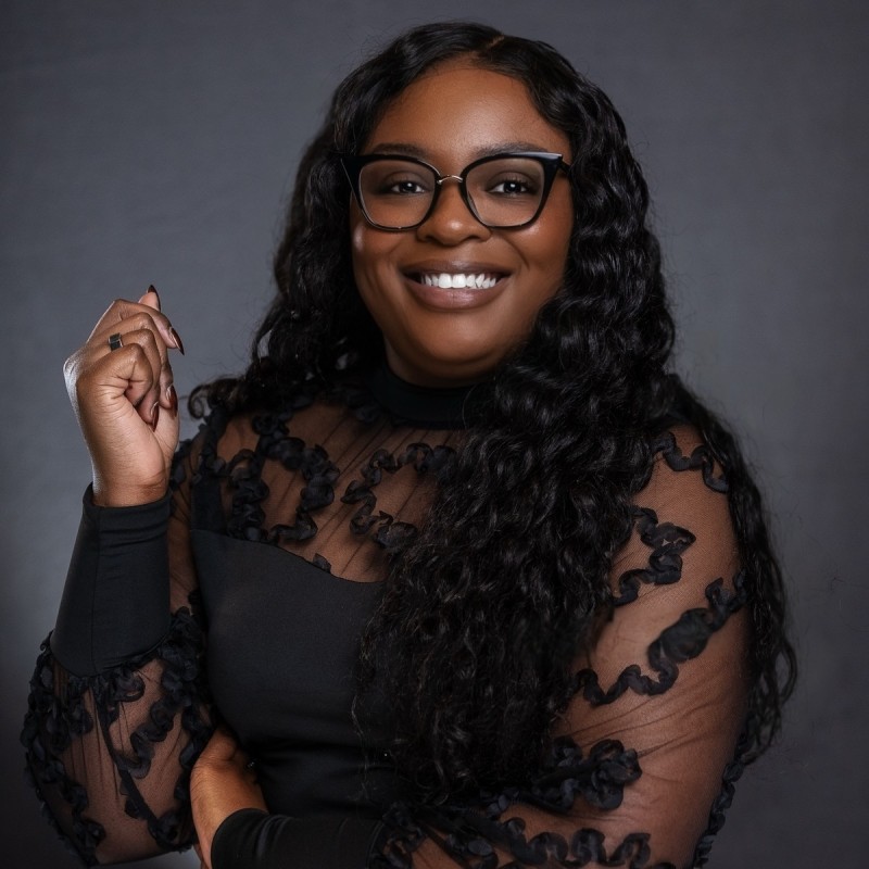 a person wearing glasses and a black dress