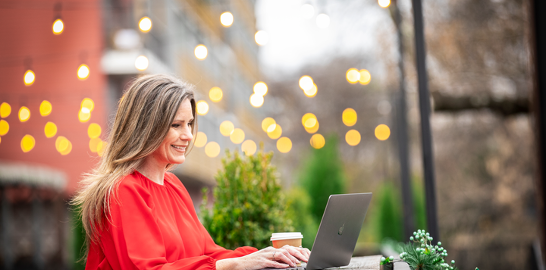 Cox employee working on laptop outdoors