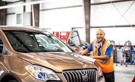 A Cox auto technician working on a car