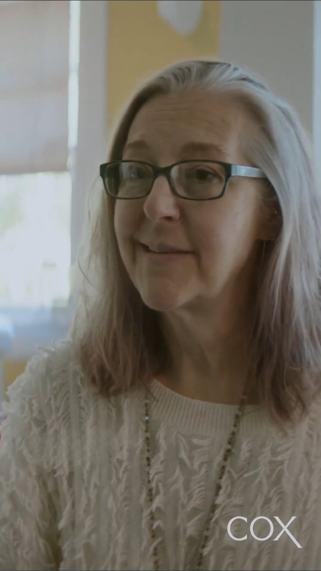 a person wearing glasses and a white sweater