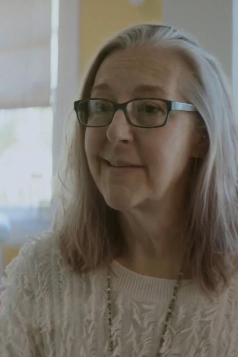 a person wearing glasses and a white sweater