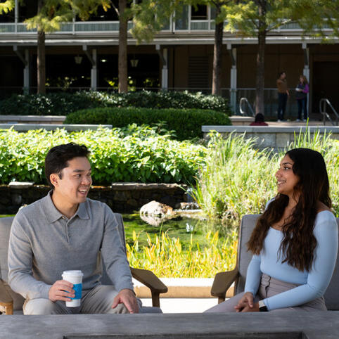 two Cox employees sitting at a table outside