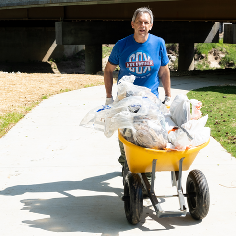 Cox employee volunteering and picking up trash