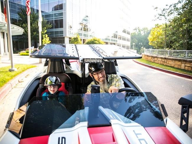 Cox employee racing a car with his son