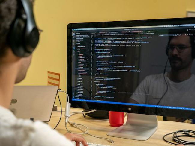 Cox employee coding on computer