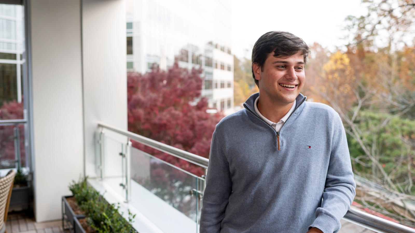 a person smiling outside on a balcony