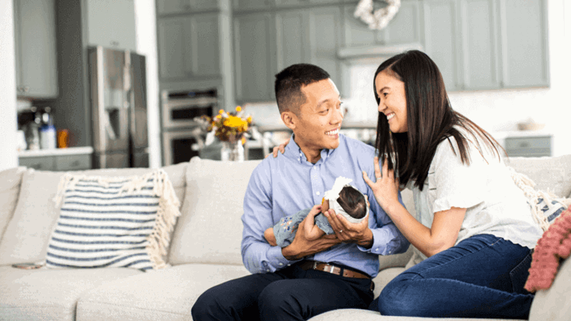 Cox employee smiling on couch with family