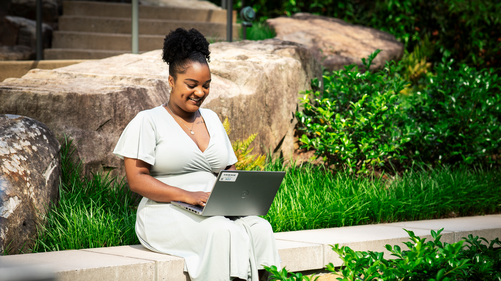Cox employee working on laptop outdoors (1)
