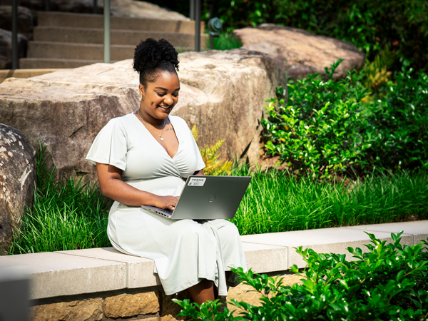 Cox employee working on laptop outdoors (1)