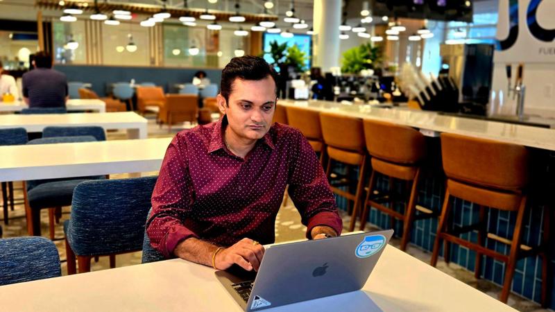 a person sitting at a table with a laptop