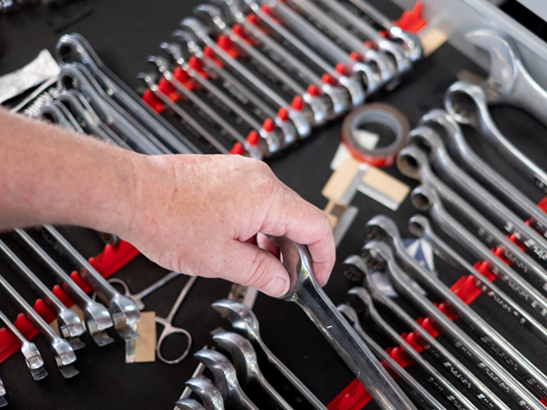 A hand picking up a wrench