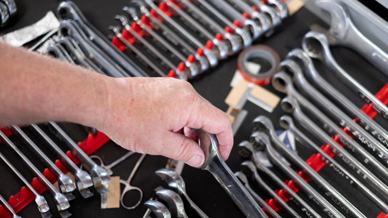 A hand picking up a wrench