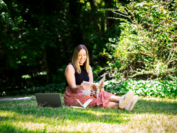 Cox Enterprises employee reading a book outdoors