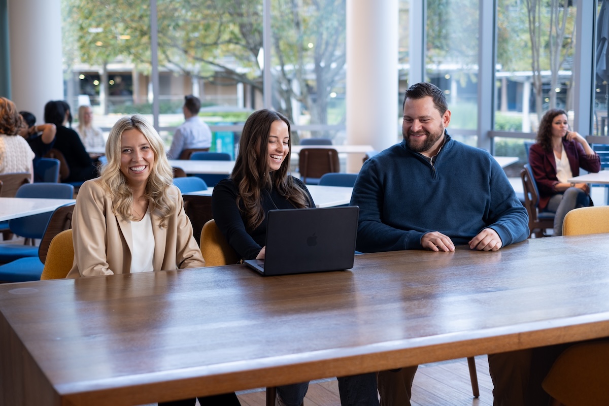 a group of people sitting at a table with a laptop