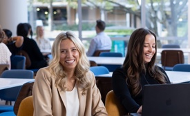 a group of people sitting at a table with a laptop