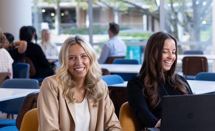 a group of people sitting at a table with a laptop