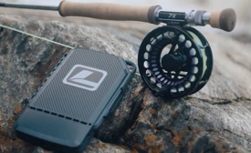 a fishing rod and a phone on a rock