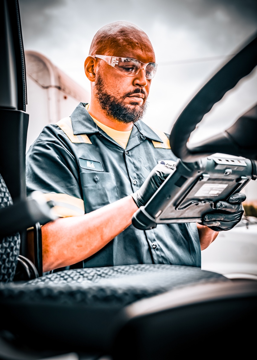 a person in a uniform and goggles holding a tablet