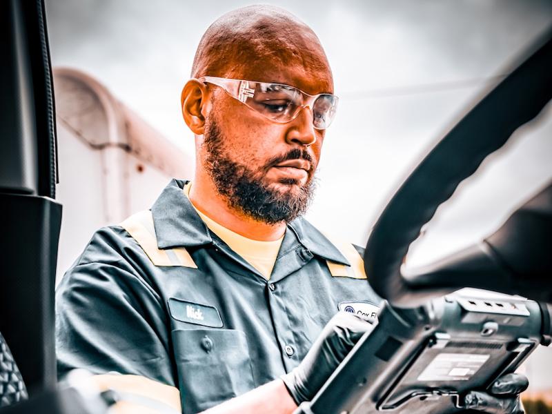 a person in a uniform and goggles holding a tablet