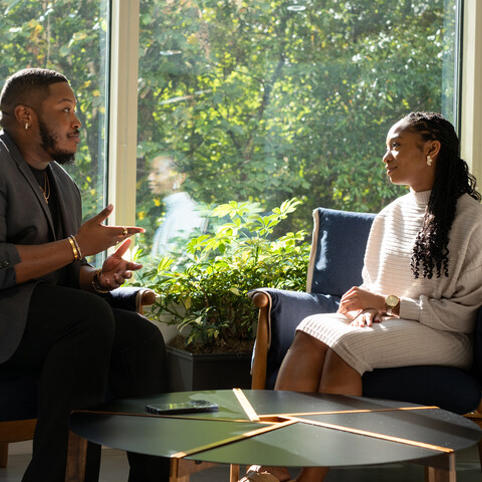 two Cox employees sitting in chairs talking
