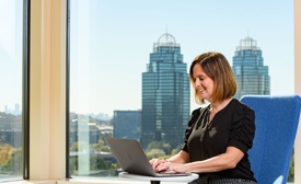 Cox employee sitting at a table with a laptop