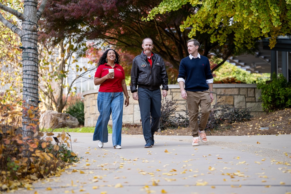 a group of people walking on a sidewalk