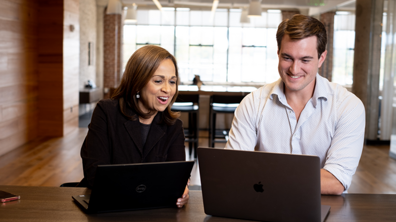 Cox employees collaborating on laptops