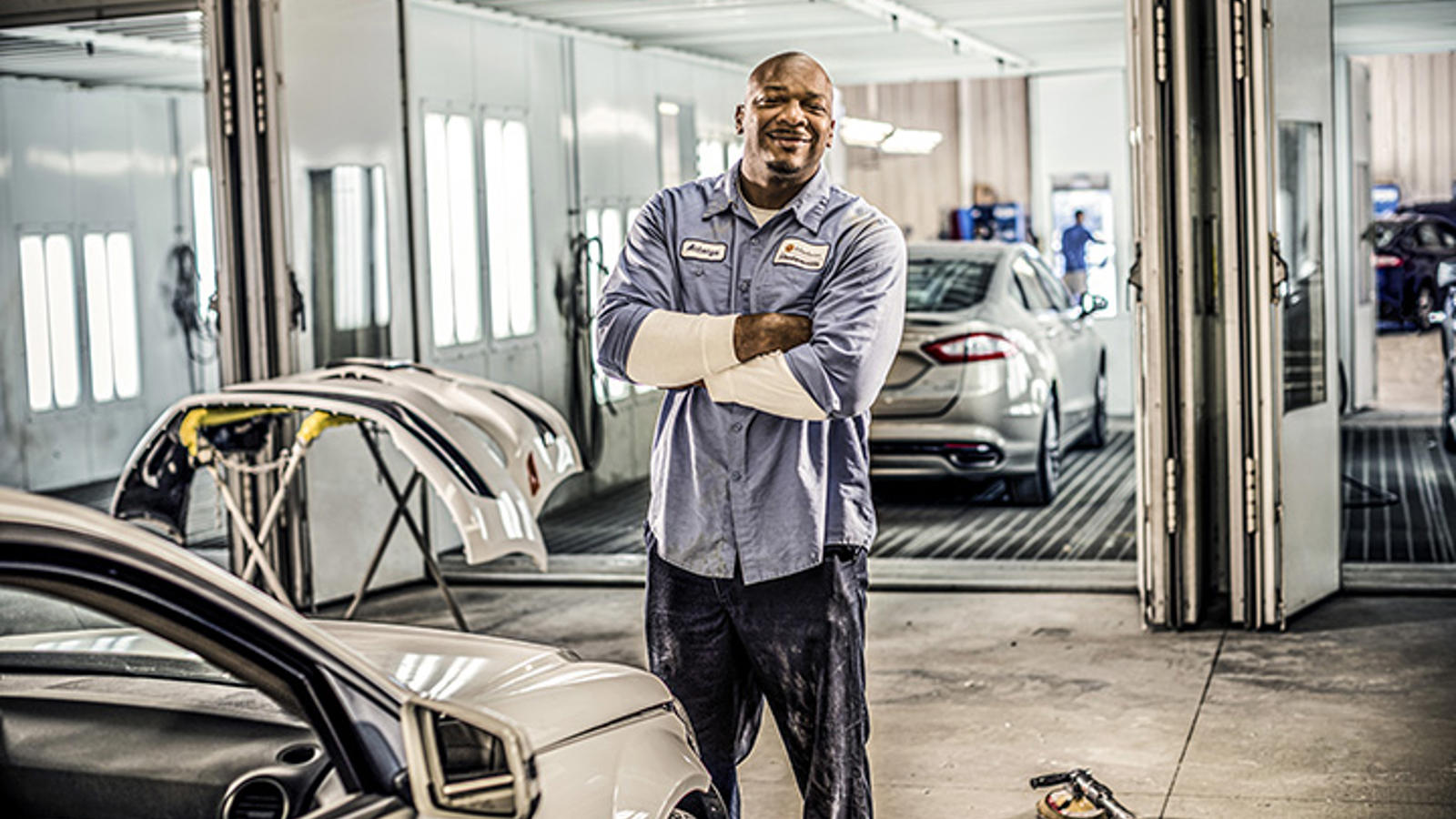 Cox auto tech crossing his arms and smiling