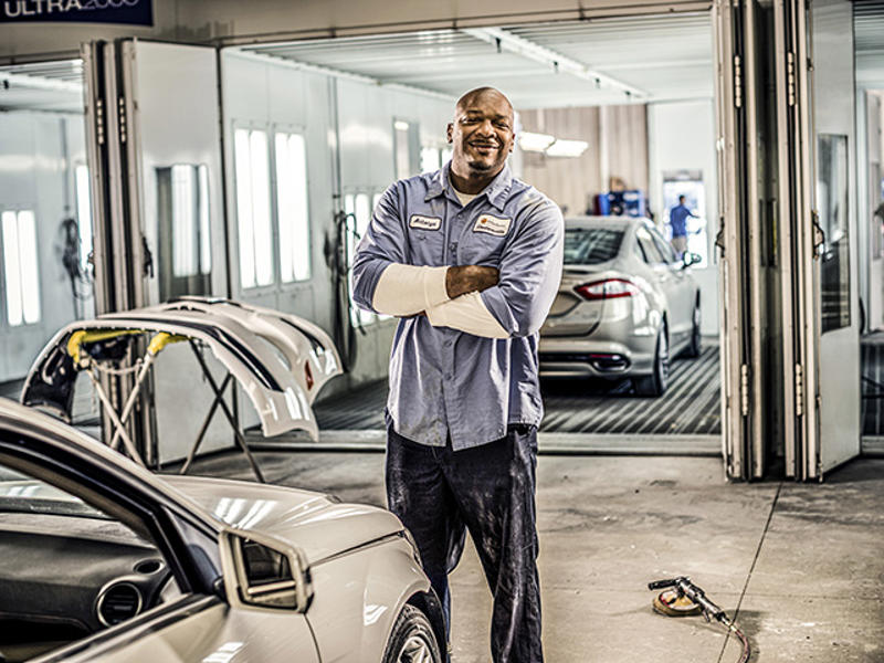 Cox auto tech crossing his arms and smiling
