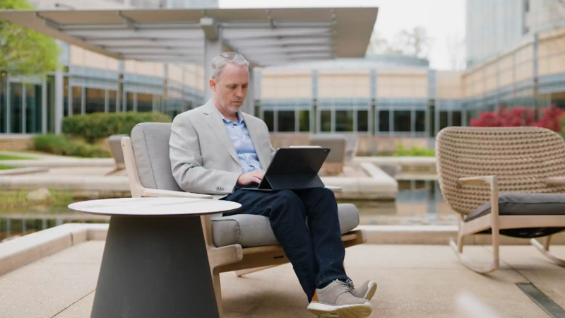David Rice cox employee working on laptop by the ponds