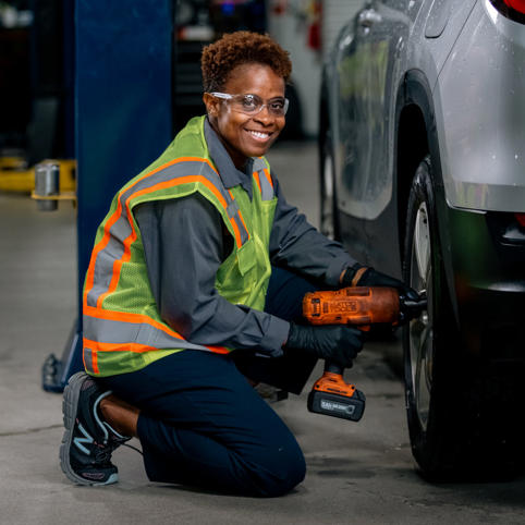 Cox automotive woman mechanic fixing car tire