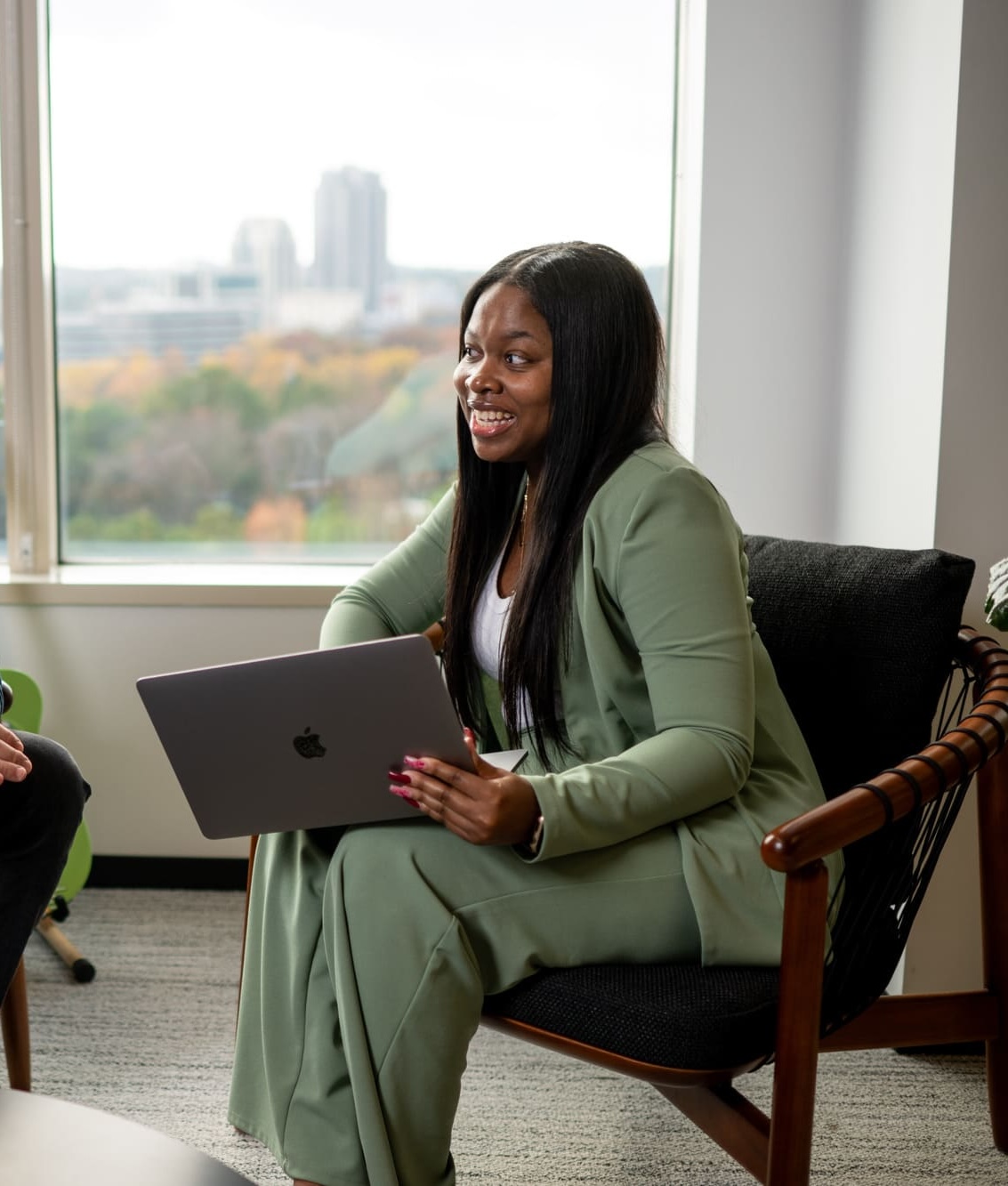 a cox employee sitting in a chair holding a laptop