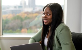 a cox employee sitting in a chair holding a laptop
