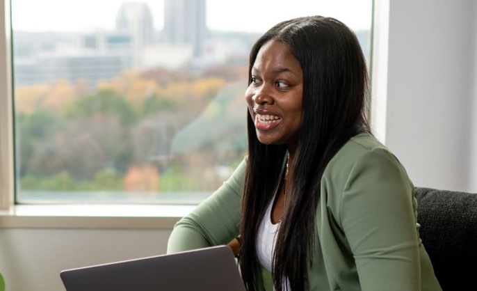 a cox employee sitting in a chair holding a laptop